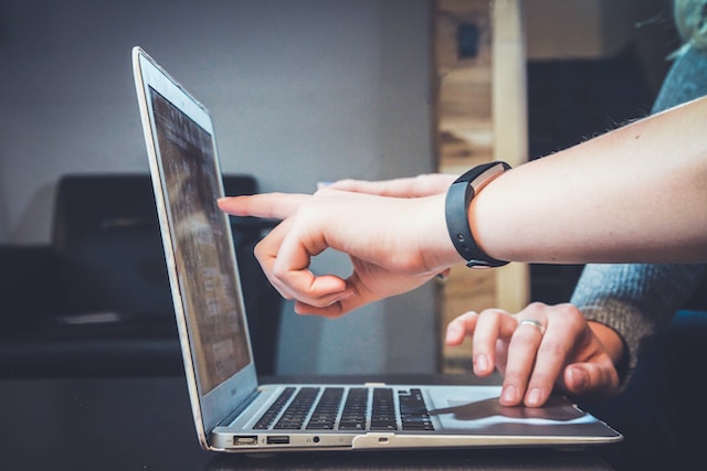 Student pointing to laptop screen seeking online term paper help